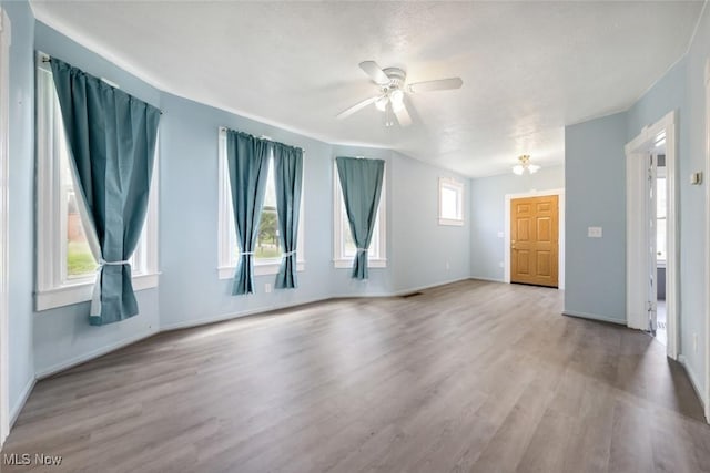 3399 E 65th St, Cleveland, OH 44127 - empty room with wood finished floors, ceiling fan, and baseboards