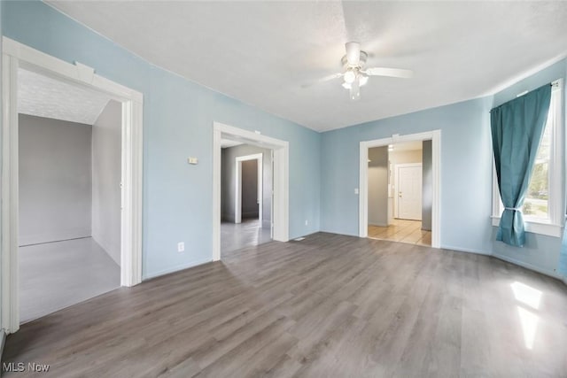 3399 E 65th St, Cleveland, OH 44127 - empty room featuring a ceiling fan, wood finished floors, and baseboards