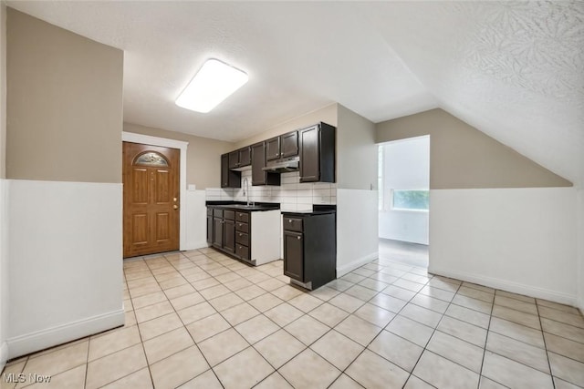 3399 E 65th St, Cleveland, OH 44127 - kitchen featuring vaulted ceiling, baseboards, light tile patterned flooring, and decorative backsplash