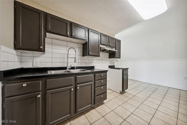 3399 E 65th St, Cleveland, OH 44127 - kitchen with a sink, dark countertops, backsplash, light tile patterned flooring, and dark brown cabinets