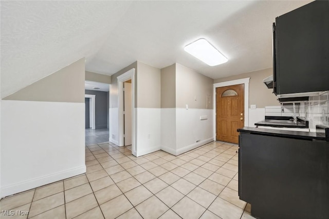 3399 E 65th St, Cleveland, OH 44127 - kitchen featuring baseboards, light tile patterned flooring, vaulted ceiling, and a sink