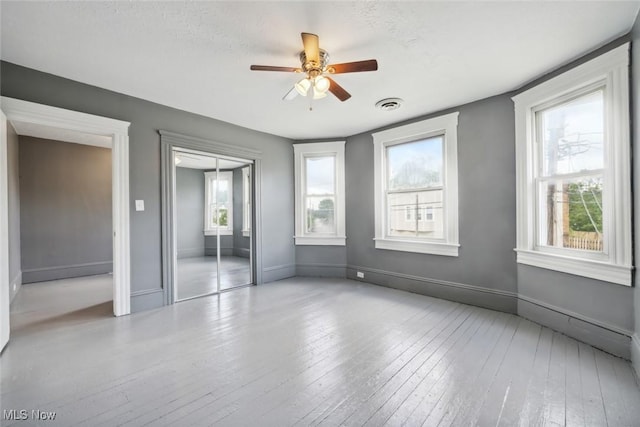 3399 E 65th St, Cleveland, OH 44127 - unfurnished bedroom featuring baseboards, hardwood / wood-style floors, a closet, and ceiling fan