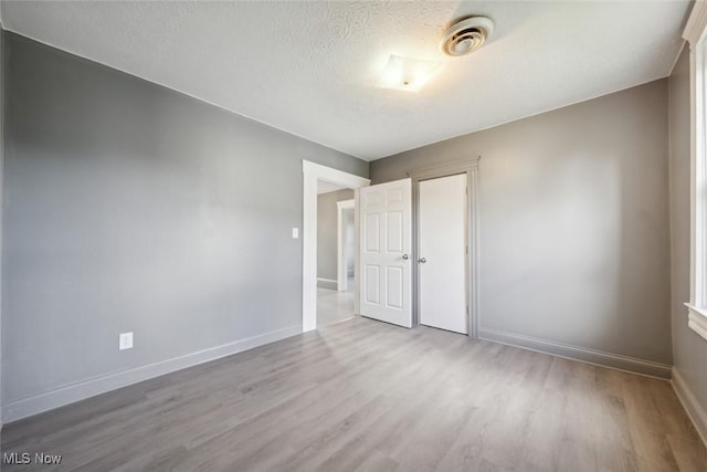 3399 E 65th St, Cleveland, OH 44127 - unfurnished room featuring wood finished floors, baseboards, and a textured ceiling