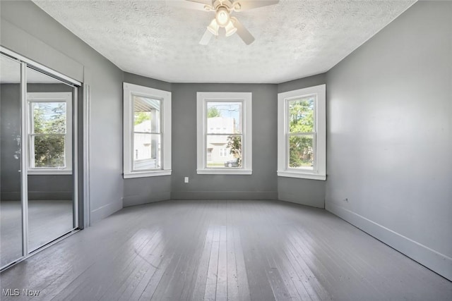 3399 E 65th St, Cleveland, OH 44127 - empty room with a ceiling fan, baseboards, a textured ceiling, and hardwood / wood-style floors