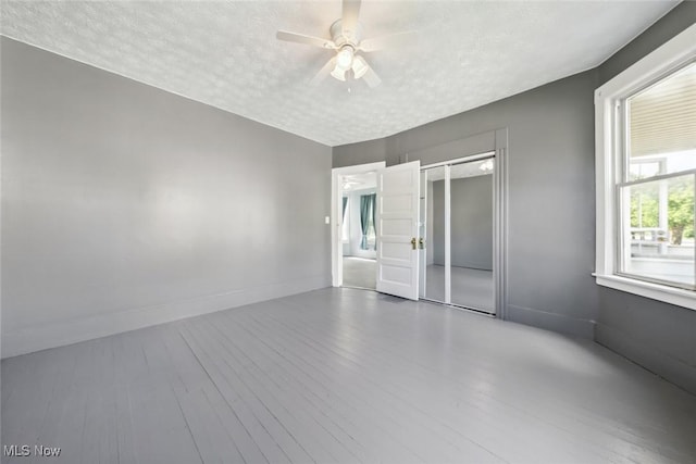 3399 E 65th St, Cleveland, OH 44127 - empty room featuring a textured ceiling, a ceiling fan, wood finished floors, and baseboards