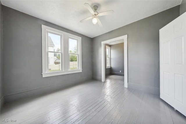 3399 E 65th St, Cleveland, OH 44127 - unfurnished bedroom featuring baseboards, hardwood / wood-style flooring, and ceiling fan