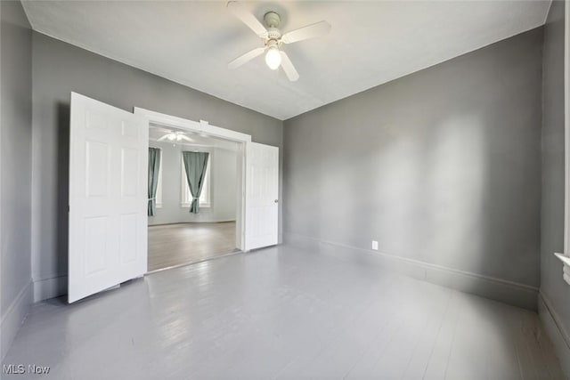 3399 E 65th St, Cleveland, OH 44127 - unfurnished bedroom featuring baseboards and a ceiling fan