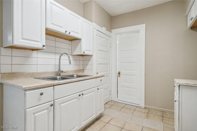3399 E 65th St, Cleveland, OH 44127 - kitchen featuring a sink, light countertops, backsplash, and white cabinets