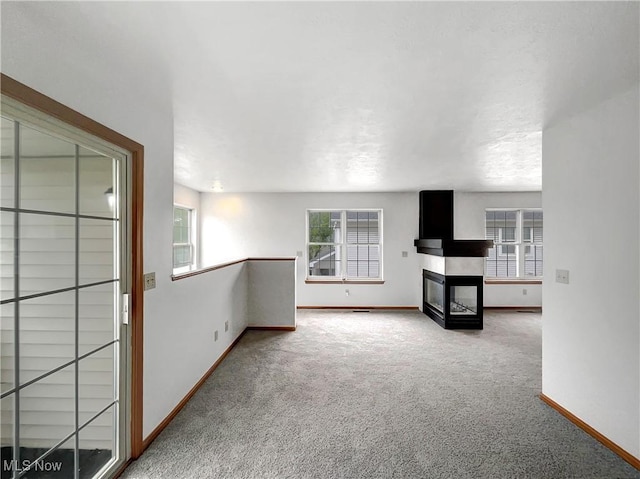 23135 Grist Mill Ct Unit 29C, Olmsted Falls, OH 44138 - unfurnished living room with baseboards, carpet, and a multi sided fireplace