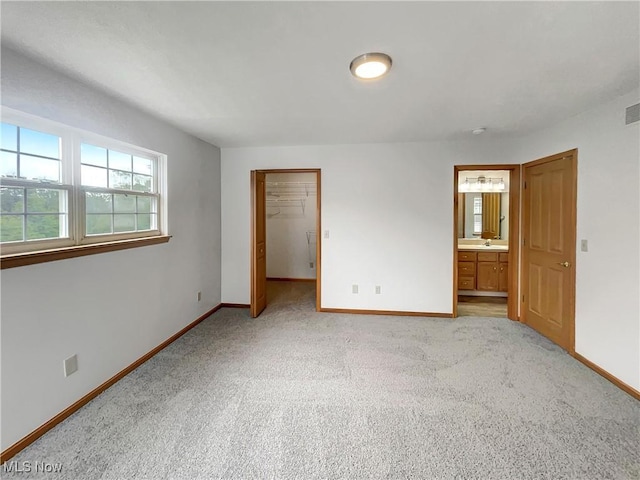 23135 Grist Mill Ct Unit 29C, Olmsted Falls, OH 44138 - unfurnished bedroom featuring baseboards, light colored carpet, and a spacious closet