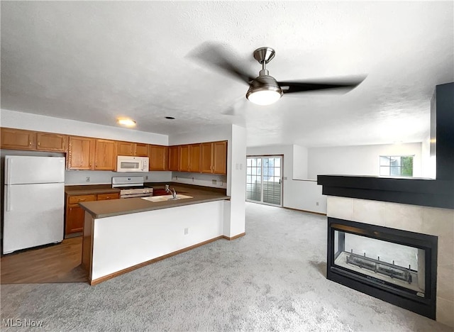 23135 Grist Mill Ct Unit 29C, Olmsted Falls, OH 44138 - kitchen with white appliances, brown cabinets, light colored carpet, ceiling fan, and dark countertops