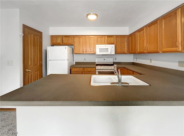23135 Grist Mill Ct Unit 29C, Olmsted Falls, OH 44138 - kitchen featuring white appliances, a sink, dark countertops, brown cabinets, and a peninsula