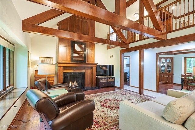 5074 Tall Timbers Dr, Richfield, OH 44286 - living area with high vaulted ceiling, wood finished floors, a high end fireplace, beamed ceiling, and baseboards