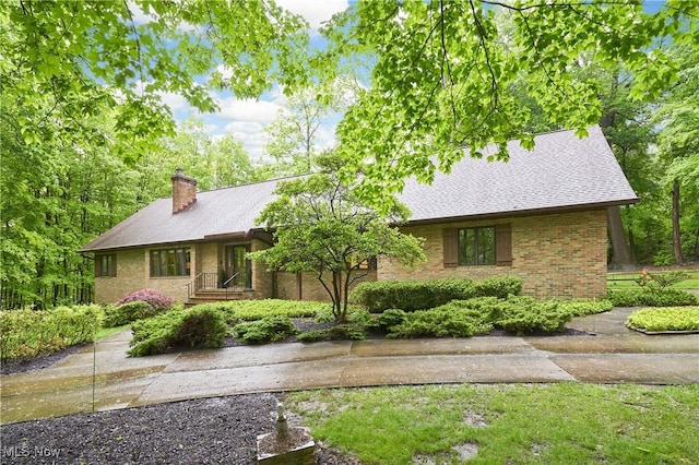 5074 Tall Timbers Dr, Richfield, OH 44286 - view of front of property featuring a chimney, brick siding, and roof with shingles