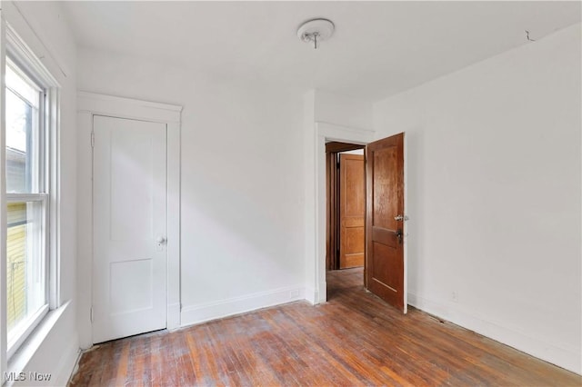 851 Paxton Rd, Cleveland, OH 44108 - unfurnished bedroom with multiple windows, wood finished floors, and baseboards