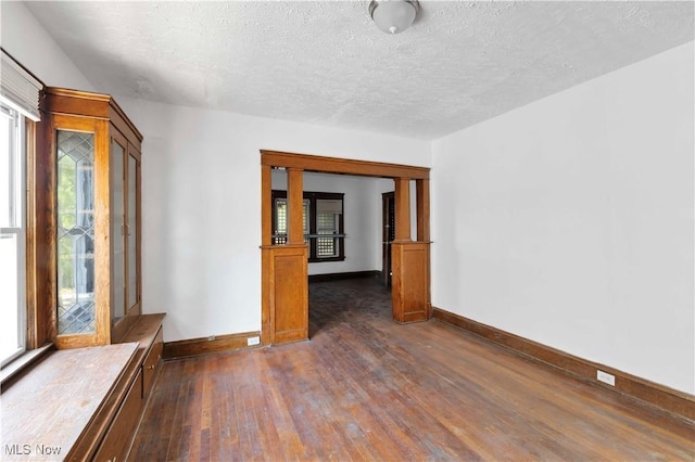 851 Paxton Rd, Cleveland, OH 44108 - empty room featuring healthy amount of natural light, dark wood-style floors, baseboards, and a textured ceiling