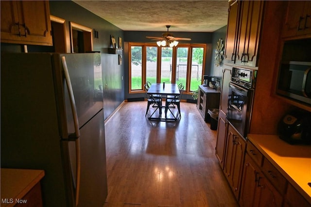 5399 N Elyria Rd, West Salem, OH 44287 - kitchen featuring appliances with stainless steel finishes, dark wood-style flooring, a ceiling fan, light countertops, and a textured ceiling
