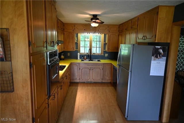 5399 N Elyria Rd, West Salem, OH 44287 - kitchen with freestanding refrigerator, a sink, a ceiling fan, oven, and light wood-type flooring