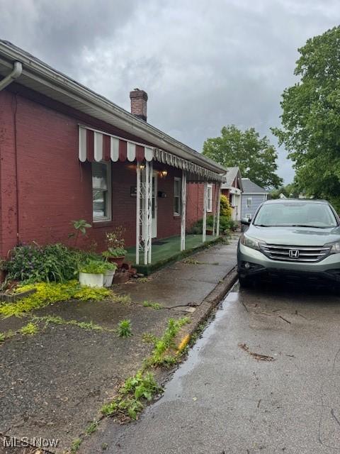 801 High St, Wellsburg, WV 26070 - view of side of home featuring a chimney and brick siding