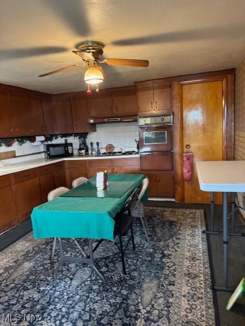 801 High St, Wellsburg, WV 26070 - kitchen featuring black appliances, a warming drawer, a ceiling fan, brown cabinetry, and under cabinet range hood