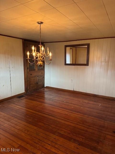 801 High St, Wellsburg, WV 26070 - unfurnished dining area featuring hardwood / wood-style flooring, a chandelier, baseboards, and wooden walls