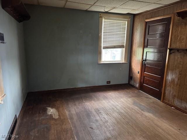 801 High St, Wellsburg, WV 26070 - spare room with wood-type flooring, a drop ceiling, baseboards, and wooden walls