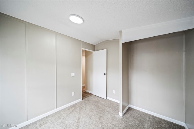 141 Marilyn Dr, Madison, OH 44057 - unfurnished bedroom with carpet floors, baseboards, vaulted ceiling, and a textured ceiling