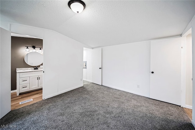 141 Marilyn Dr, Madison, OH 44057 - unfurnished bedroom with vaulted ceiling, a textured ceiling, carpet flooring, ensuite bath, and baseboards