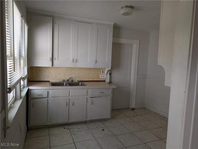 1367 Clearaire Rd, Cleveland, OH 44110 - kitchen with a sink, light countertops, white cabinetry, backsplash, and light tile patterned flooring