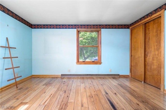 625 Henry St, Toronto, OH 43964 - unfurnished bedroom with light wood-style floors, baseboards, baseboard heating, and a closet