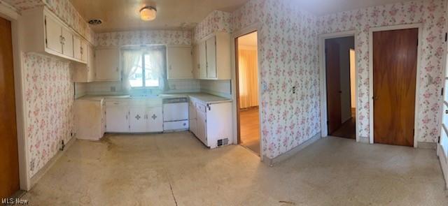 1081 Carver Rd, Cleveland Heights, OH 44112 - kitchen with wallpapered walls, white dishwasher, light countertops, and white cabinets