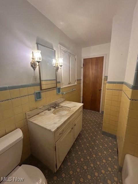 1081 Carver Rd, Cleveland Heights, OH 44112 - bathroom featuring tile walls, wainscoting, toilet, and vanity