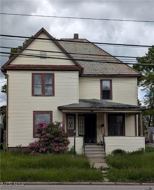 179 N Lyman St, Wadsworth, OH 44281 - view of front facade with covered porch, a high end roof, and a chimney