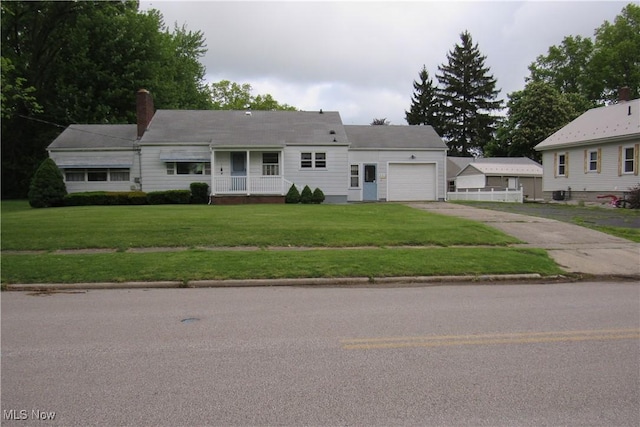 2313 W 13th St, Ashtabula, OH 44004 - view of front facade with an attached garage, asphalt driveway, a front yard, and a chimney