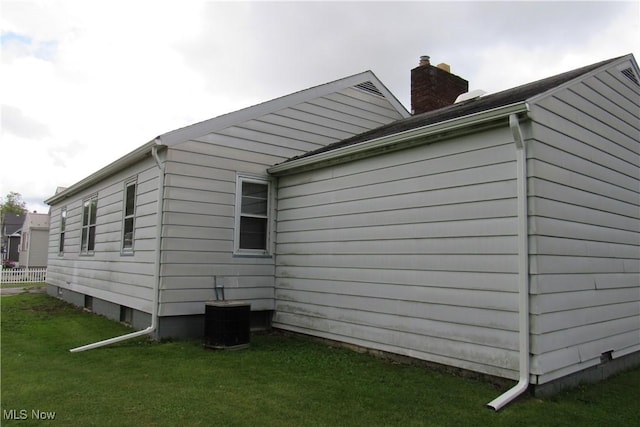 2313 W 13th St, Ashtabula, OH 44004 - view of side of home with a lawn, cooling unit, and a chimney