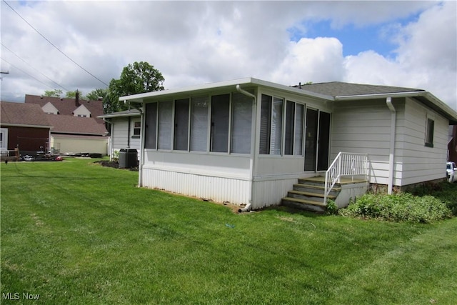 3318 Avon Blvd, Ashtabula, OH 44004 - back of house with cooling unit, a yard, and a sunroom