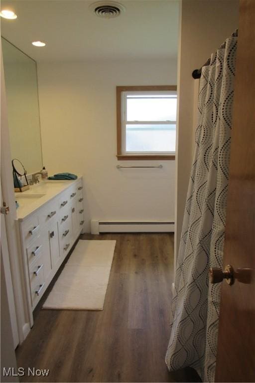 3318 Avon Blvd, Ashtabula, OH 44004 - bathroom featuring a baseboard radiator, double vanity, wood finished floors, and recessed lighting