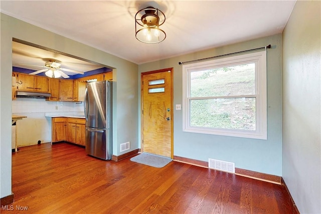 2920 Linda Way, Steubenville, OH 43952 - kitchen with freestanding refrigerator, brown cabinetry, dark wood-style floors, under cabinet range hood, and light countertops