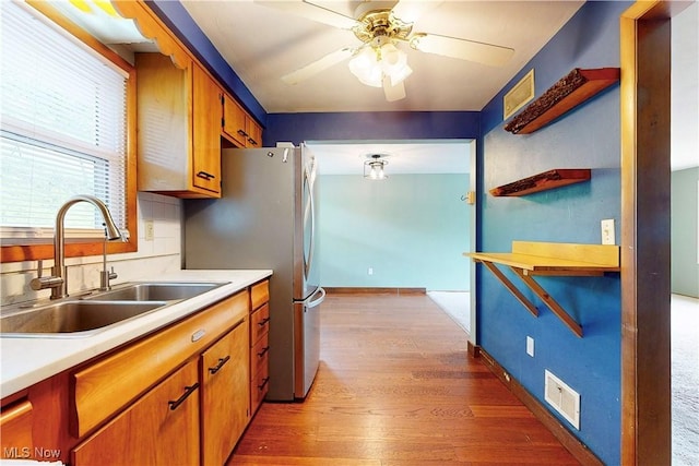 2920 Linda Way, Steubenville, OH 43952 - kitchen with a sink, a ceiling fan, wood finished floors, light countertops, and brown cabinetry