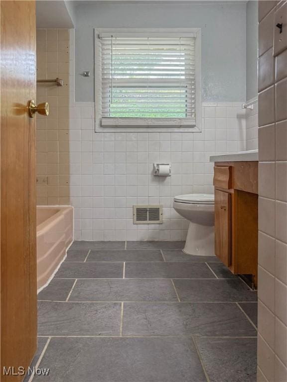 2920 Linda Way, Steubenville, OH 43952 - bathroom featuring tile walls, vanity, toilet, a bath, and a wainscoted wall