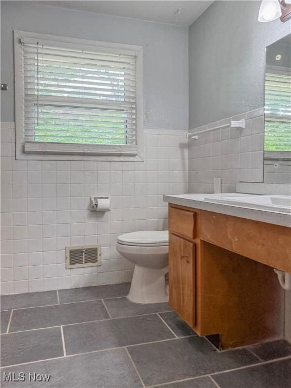 2920 Linda Way, Steubenville, OH 43952 - bathroom with tile walls, vanity, toilet, tile patterned floors, and a wainscoted wall