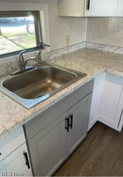 311 4th St, Beverly, OH 45714 - kitchen featuring a sink, dark wood-style floors, decorative backsplash, and white cabinetry
