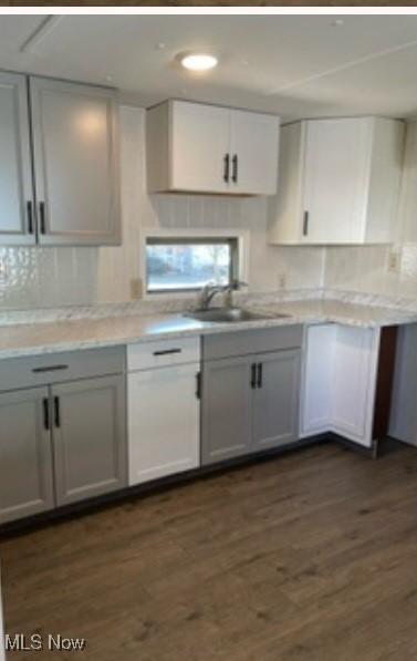 311 4th St, Beverly, OH 45714 - kitchen with a sink, backsplash, light countertops, and dark wood-style flooring