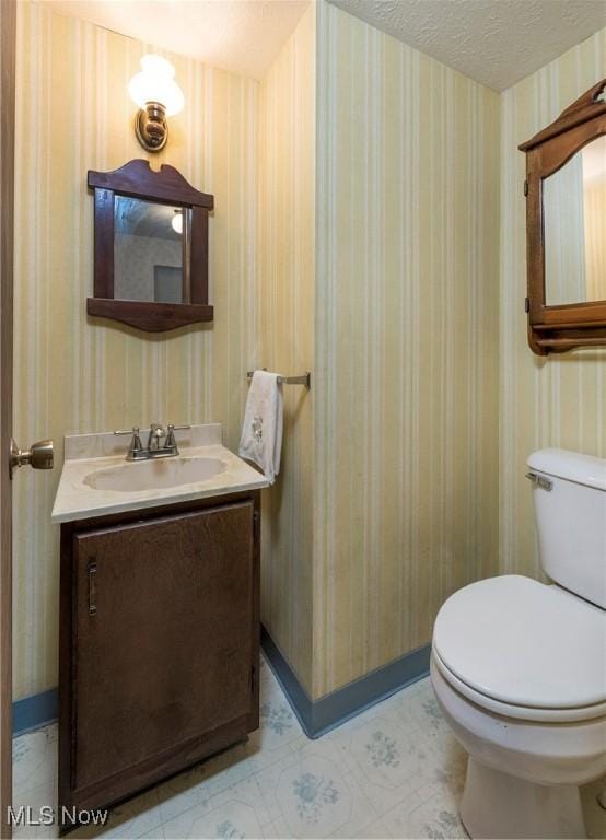 6533 Engle Rd, Brook Park, OH 44142 - half bath featuring wallpapered walls, toilet, vanity, and baseboards