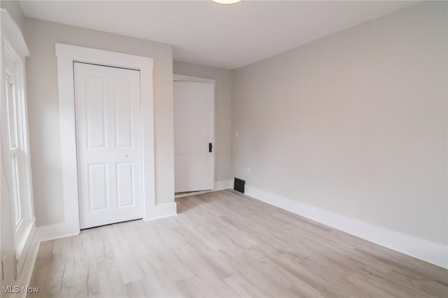 207 W Main St, Saint Clairsville, OH 43950 - unfurnished bedroom with light wood-type flooring, baseboards, and a closet