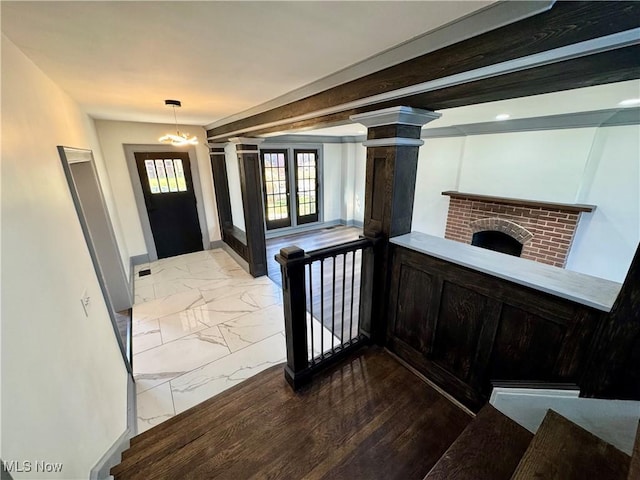 1247 11th St NW, Canton, OH 44703 - entrance foyer with marble finish floors, decorative columns, a brick fireplace, and baseboards