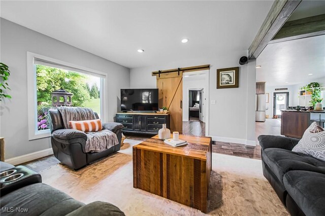 9012 Winesburg Rd, Dundee, OH 44624 - living room with a barn door, baseboards, recessed lighting, and light wood-style floors