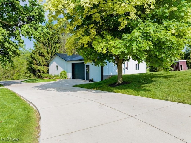 9012 Winesburg Rd, Dundee, OH 44624 - view of property hidden behind natural elements featuring a front lawn, concrete driveway, and an attached garage