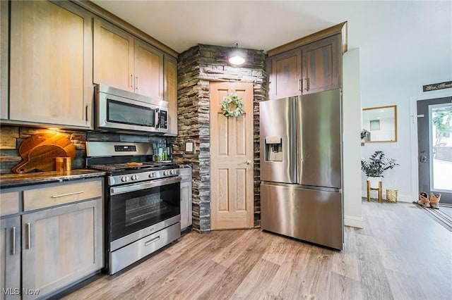 9012 Winesburg Rd, Dundee, OH 44624 - kitchen with stainless steel appliances, light wood-style flooring, dark stone countertops, and baseboards