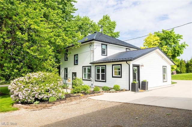 9012 Winesburg Rd, Dundee, OH 44624 - view of home's exterior featuring concrete driveway, metal roof, and a patio area